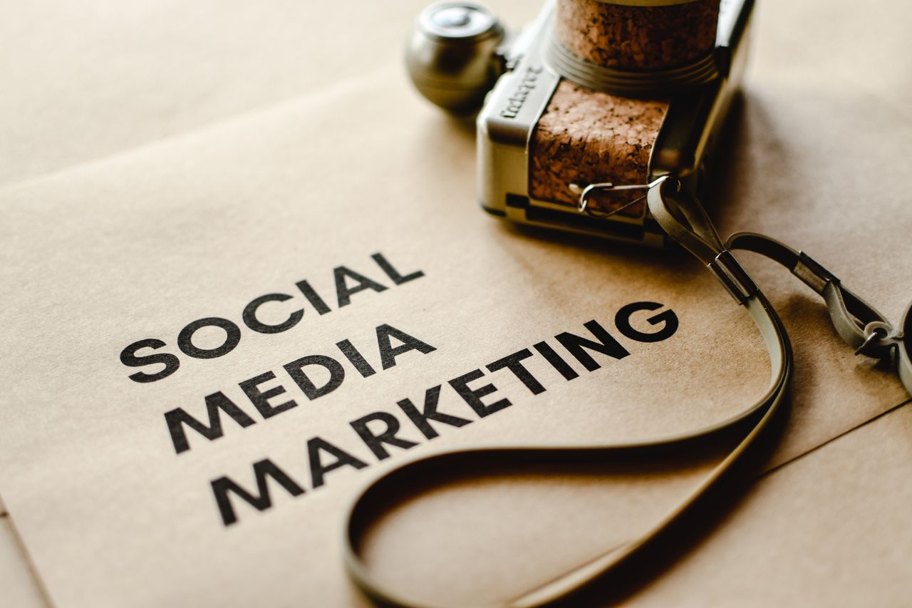 A close-up view of a camera resting on brown paper with Social Media Marketing text, highlighting digital marketing themes.
